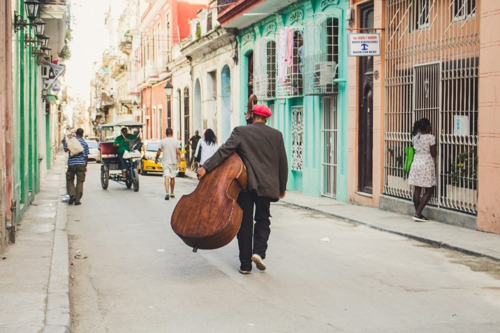 Man walks down street with double bass